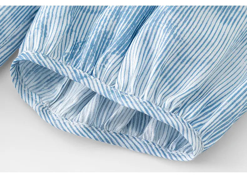 Close-up of the elasticated balloon sleeve cuff on a Brynja silk-blend midi dress, showing the delicate blue and white watercolor stripe print and lightweight fabric texture.