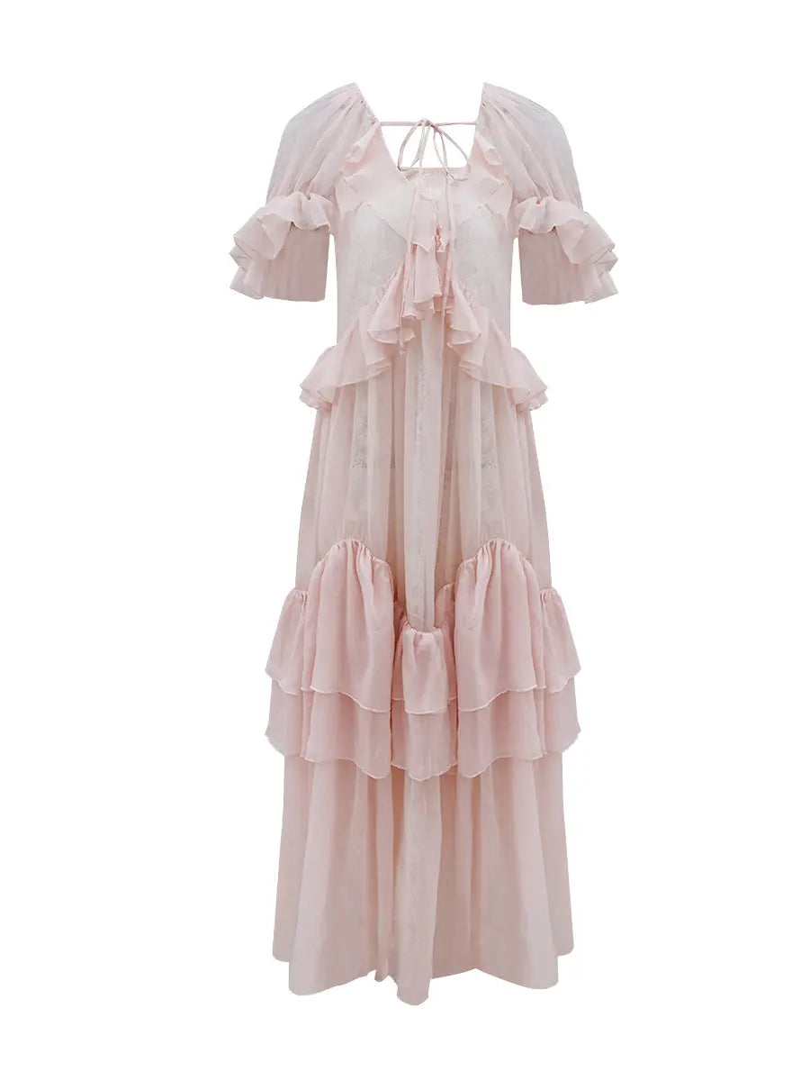 Pale blush pink maxi dress featuring cascading tiered ruffles, flutter sleeves, and a sheer georgette overlay with a delicate lace pattern, shown on a white background.