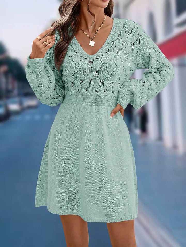 Model wearing a mint green V-neck knit sweater dress with intricate fish-scale patterned yoke and sleeves, defined elasticated waist, and flared A-line skirt.